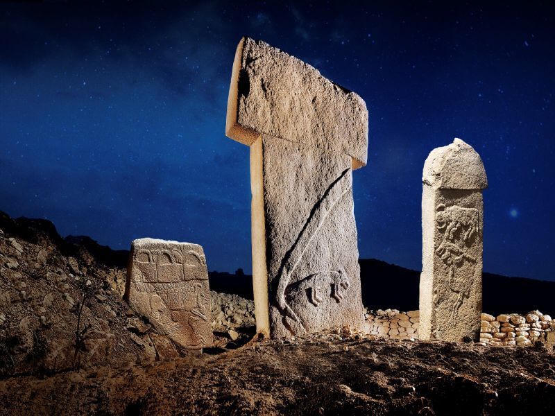 Rekonstrukcja nocna filarów T w Göbekli Tepe z reliefami zwierząt.